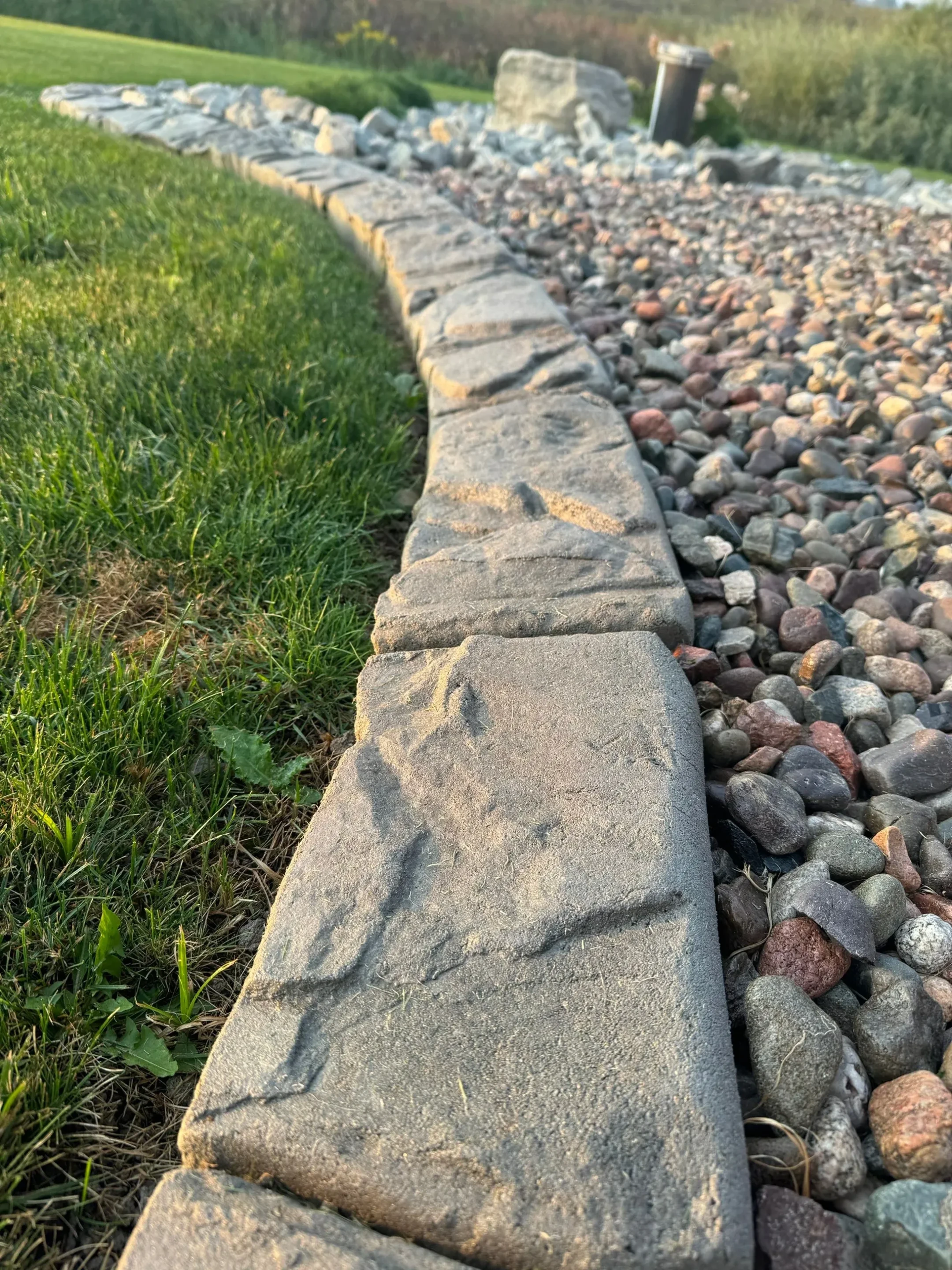 Cobblestone stamped curbing along garden path